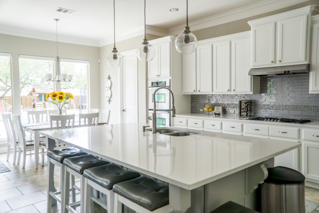 pexels-photo-1080721-1080721 Spacious modern kitchen with white cabinets and island in natural light.